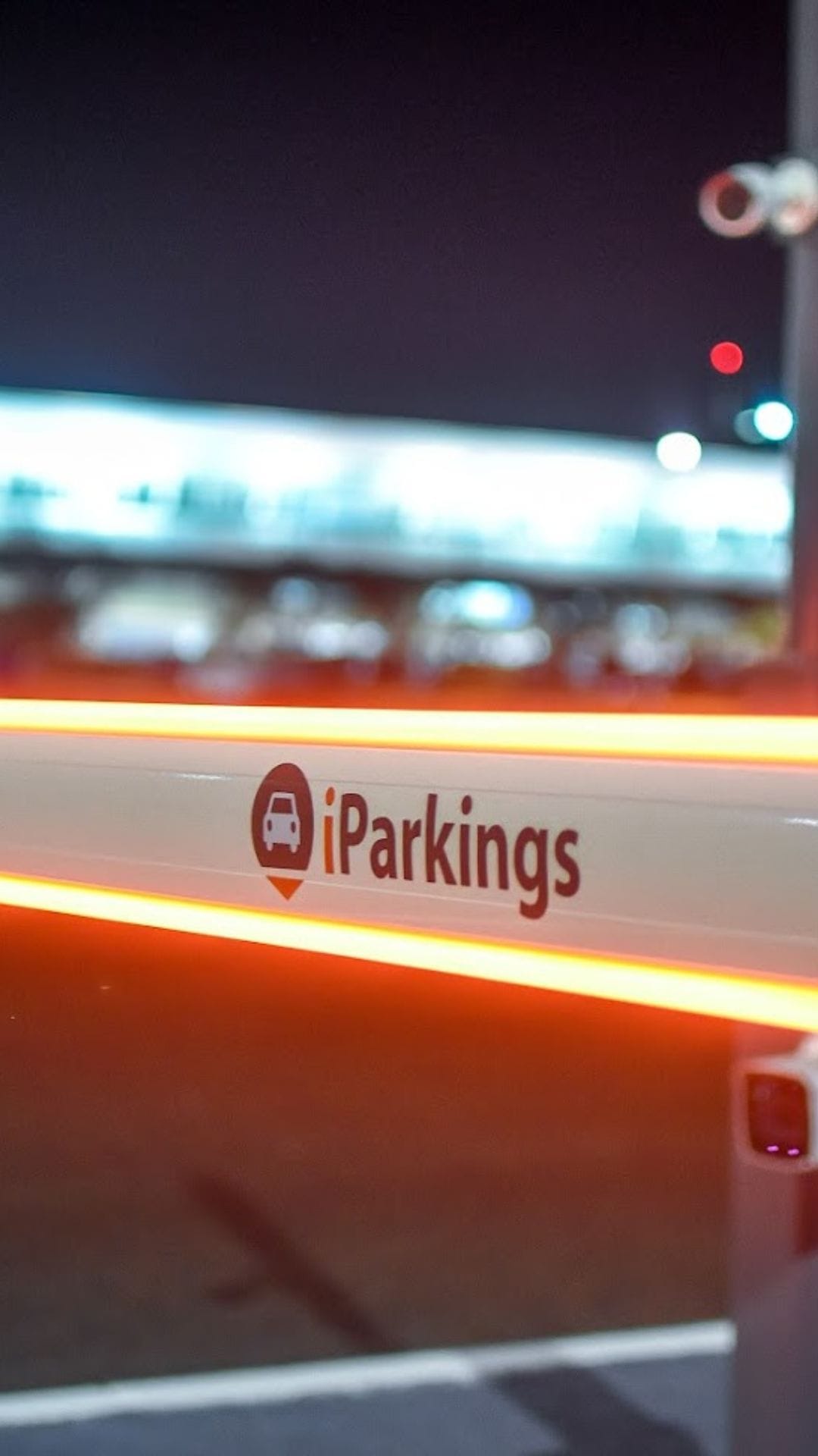 Barrera vehicular automática iluminada con LED en acceso comercial