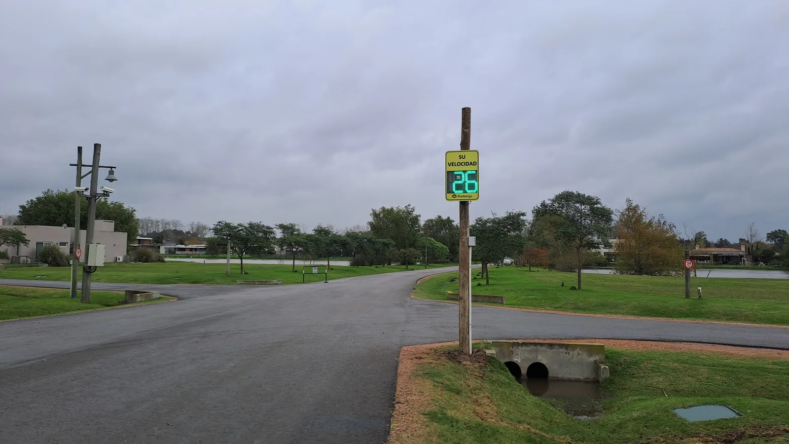 Radar de velocidad disuasorio iParkings en avenida interna arbolada