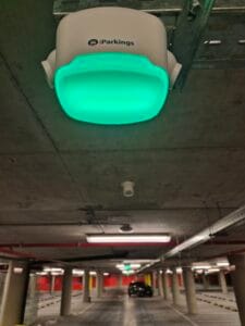 Sensor de guiado inteligente iParkings con indicador verde de plaza libre en el estacionamiento de Cosmos Montevideo